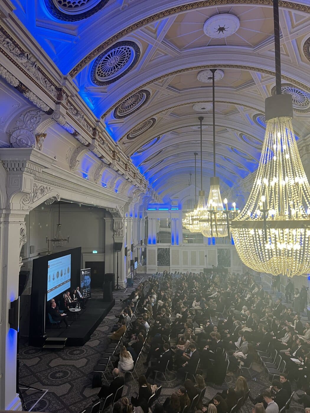 Historic hall with chandeliers during a talk